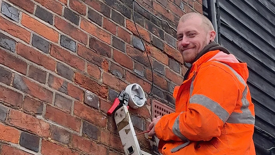 OC Fire & Security engineer fitting a CCTV camera to a brick wall