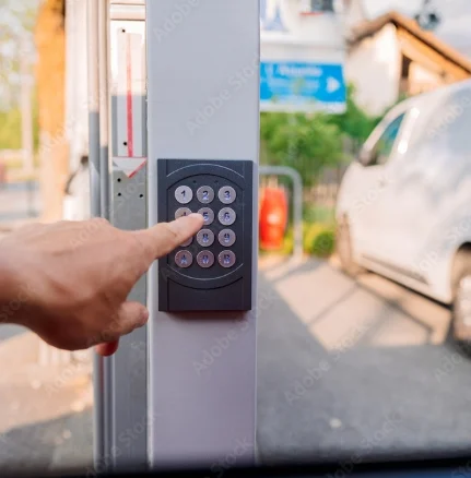 Hand pressing an access control keypad at a car park entrance